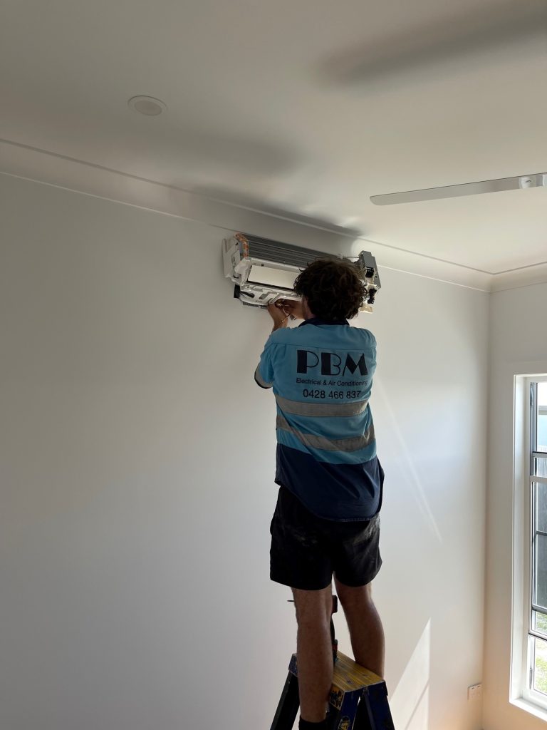 Licensed electrician installing air conditioner in Cannonvale